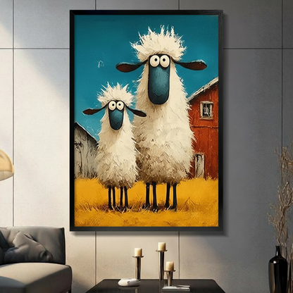 Black framed whimsical googly-eyed sheep on a farm canvas art with two shaggy cartoon sheep with big wide eyes and blue faces standing in a golden field before a red barn under a teal sky in thick oil-paint texture, displayed on a light gray tile wall above a black table with candlesticks beside a gray sofa