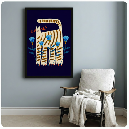 Whimsical folk art striped cat framed print — cream tabby with orange whiskers and blue cornflowers on dark navy, hung above a linen armchair in a cozy reading nook