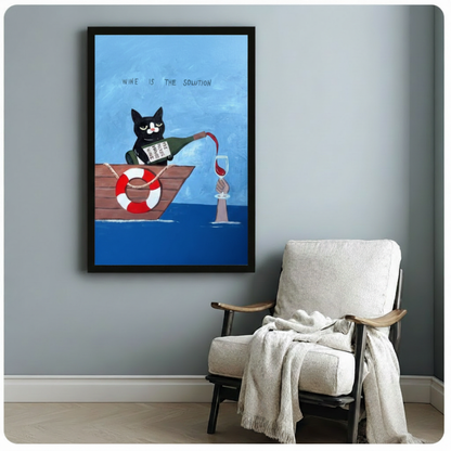 Black framed humorous wine is the solution cat canvas art featuring a black and white tuxedo cat in a rowboat pouring red wine to a hand reaching up from the blue sea, with a red and white life buoy and playful hand-drawn text on an oil-painted background, displayed on a light gray wall beside a white upholstered wooden armchair draped with a cream knit throw blanket