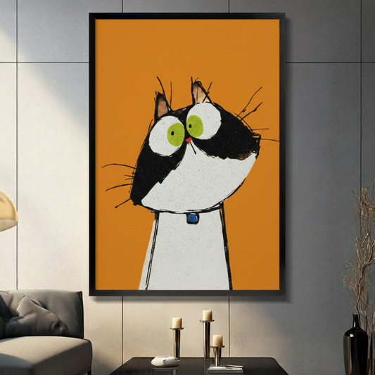 Funny wide-eyed black and white cat wall art print with blue collar on bold orange background, displayed in black frame on dark grey wall with candle decor