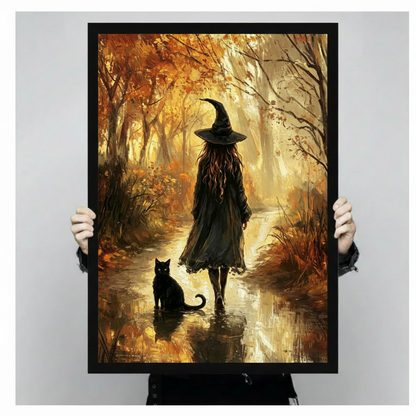 Oil painting of a witch in a black coat and pointed hat walking along a glowing autumn forest stream beside a black cat with golden foliage and warm misty light witch wall art framed print held against light gray background
