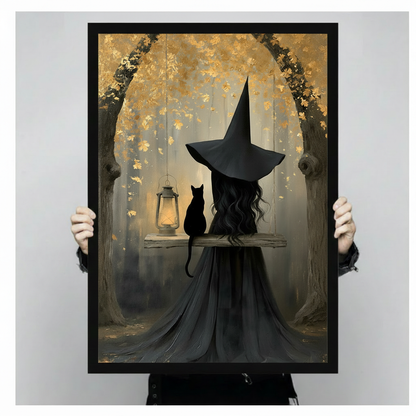 Dark fantasy art print of a mysterious witch in a tall black hat and long dark robe sitting on a swing beside a black cat and glowing vintage oil lantern beneath a golden autumn leaf canopy gothic witch and black cat wall art framed print held up against a light gray background