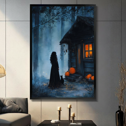Framed gothic Halloween wall art print of a witch silhouette in a black gown standing with a black cat beside a glowing forest cabin surrounded by orange pumpkins, displayed in a moody dark living room