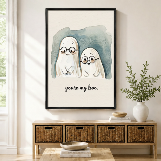You're My Boo cute ghost couple with glasses watercolor framed wall art in black frame displayed above a wooden sideboard with wicker baskets in a bright Scandinavian entryway