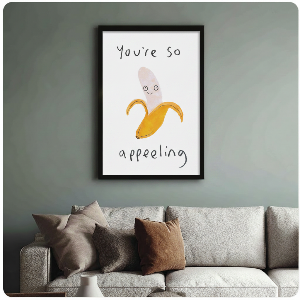 "You're So Appealing" banana art print in black frame on sage green wall, styled above neutral linen sofa in modern living room
